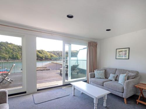 a living room with a couch and a large window at Lower Deck in Fowey