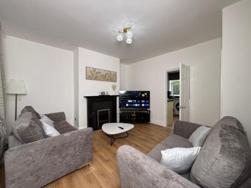 a living room with two couches and a tv at Spacious 3 Bed House Perfect for Contractors & Families with free Wi-fi and Parking in Rawmarsh