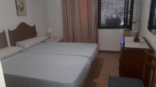 een slaapkamer met twee bedden, een bureau en een raam bij Villa Consuelo in Cambrils