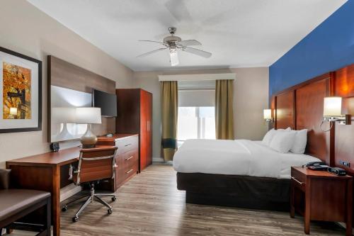 a hotel room with a bed and a desk and a computer at Comfort Suites St Charles-St Louis in St. Charles