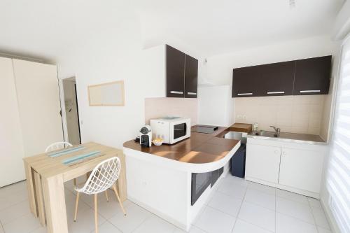a kitchen with a counter with a microwave on it at Olivéa - Écrin fleuri, terrasse & plage à 5 min in Antibes