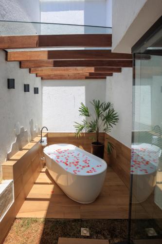 a bathroom with a bath tub and a toilet at Pousada Vinháticos in Nova Lima