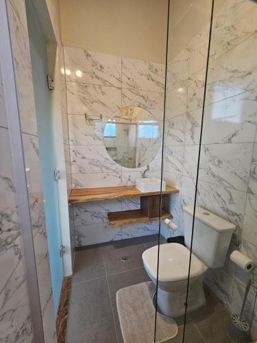 a bathroom with a toilet and a mirror at Cabana Sol Poente PR in São José dos Pinhais
