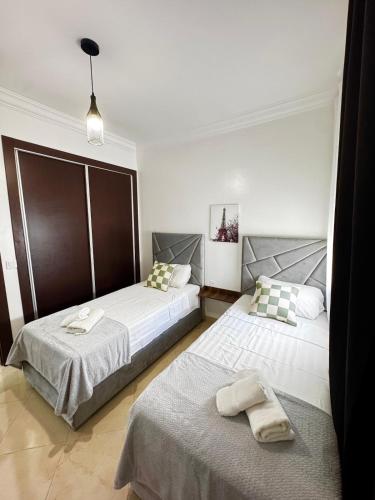a bedroom with two beds with towels on them at Appartement Tanger Stade ibn batouta in Tangier