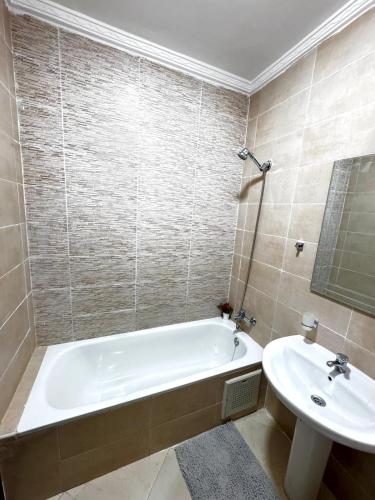 a bathroom with a bath tub and a sink at Appartement Tanger Stade ibn batouta in Tangier