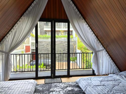 a bedroom with a large window looking out onto a balcony at Deju Cabin with Private Pool & Mountain View in Cilama