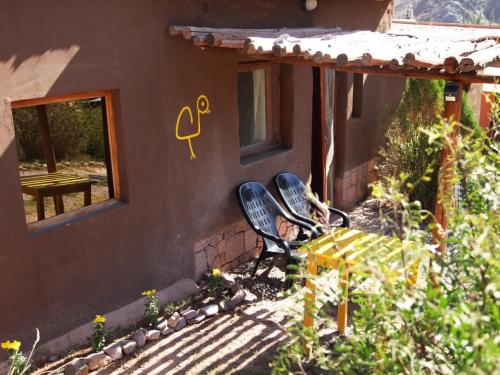 two chairs and a table in front of a house at Otro Mundo alojamiento in Maimará