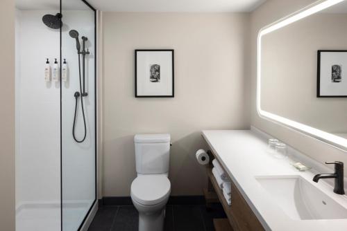 Un baño con inodoro, lavabo y ducha. en Hotel Halifax, en Halifax