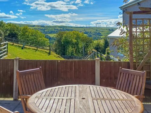 une table en bois et deux chaises sur une clôture en bois dans l'établissement Bwthyn Bwlch, à Denbigh