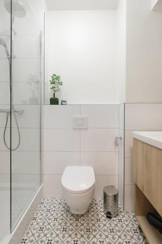 a white bathroom with a toilet and a shower at Zeitraum Racławicka in Krakow