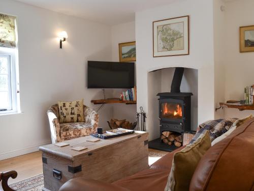 a living room with a fireplace and a couch at Grattan Cottage in Bow