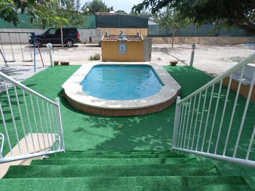 une petite piscine sur une pelouse verte avec des escaliers dans l'établissement Casa la solana, à La Molata