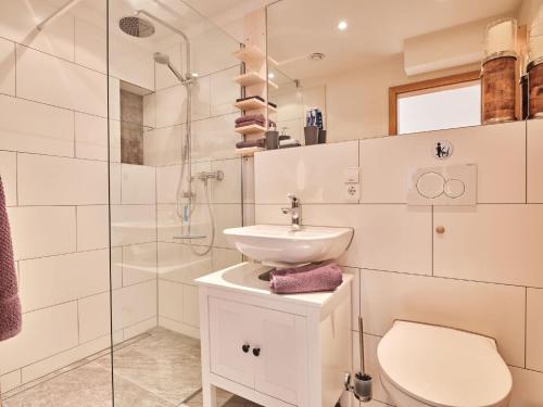 a white bathroom with a sink and a shower at Appartement Sunset, 28qm in Schluchsee