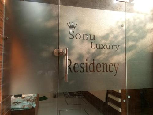 a glass door with the words sonu luxury residency on it at Sonu luxury residency hotel in Amritsar