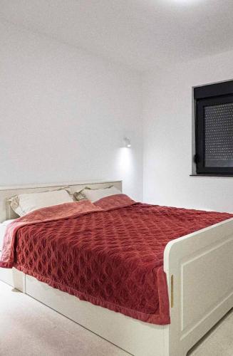 a bedroom with a large bed with a red comforter at Dream House Banja Luka in Banja Luka