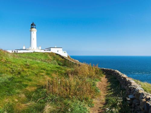 a lighthouse on a hill next to the ocean at Home Farm - The Dairy -Uk34626 in Dunragit
