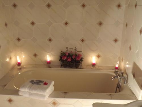 La salle de bains est pourvue d'une baignoire avec des bougies et des roses. dans l'établissement Auberge de La Halle, à Cordes-sur-Ciel