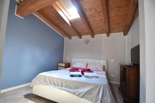 Un dormitorio con una cama con techo de madera. en AkiHouse - rooms and apartments on Garda Lake, en Lonato