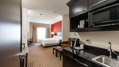 a hotel room with a bed and a kitchen at Holiday Inn Express & Suites Oklahoma City NW - Quail Springs by IHG in Oklahoma City