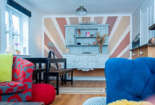 a living room with a chair and a table at Avalon Sunrise our enchanting Glastonbury cottage in Glastonbury