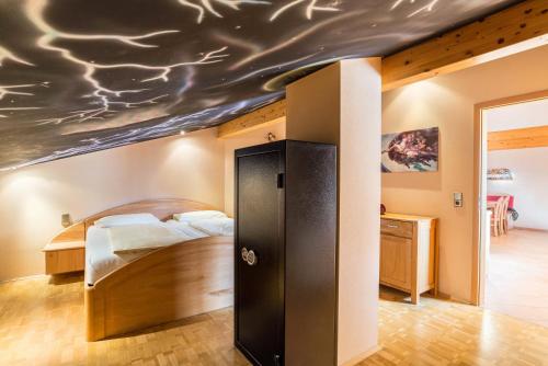 Schlafzimmer mit einem Bett und Deckengemälde in der Unterkunft Haus am Bächel in Lauf