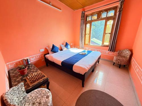 ビーアにあるSabhyata Stays Birのベッドと椅子と窓のある寝室