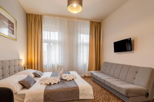 a hotel room with a bed and a couch at Hotel Brixen in Prague