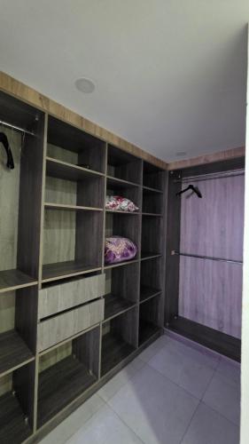 a closet with wooden shelves and a purple curtain at dar saoussen in Triffa