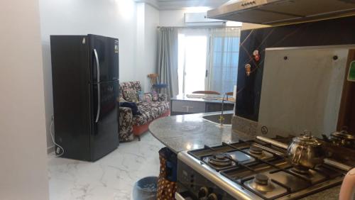 a kitchen with a black refrigerator and a stove at Juliana Beach Resort in Hurghada