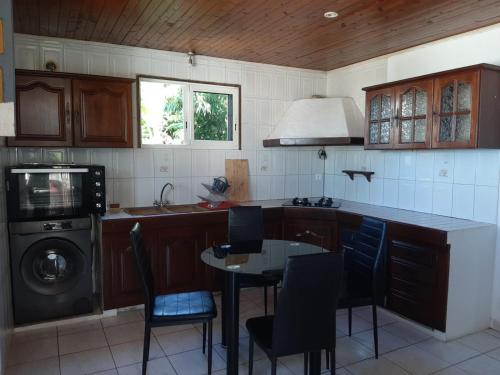 a kitchen with a table and a sink and a dishwasher at Kaz'Eliz in Le Tampon