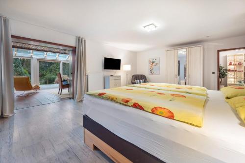 a bedroom with a large bed with a yellow blanket at Ferienhaus Timm in Meldorf