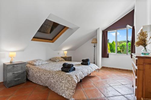 ein Schlafzimmer mit einem Bett und einem Fenster in der Unterkunft Villa de lujo en Cantabria in Puente Arce