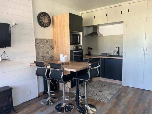 a kitchen with a wooden table and bar stools at Appartement avec chambre Gourette in Gourette