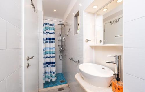 a white bathroom with a sink and a shower at Beach house Lozica by Villas Guide in Dubrovnik