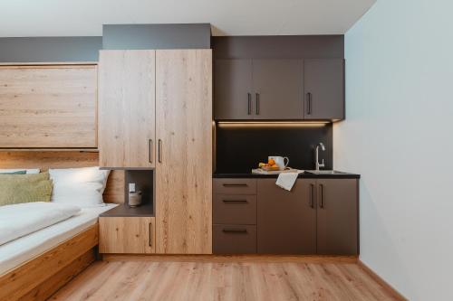een slaapkamer met een bed en een kleine keuken bij MOWO Limes in Denkendorf