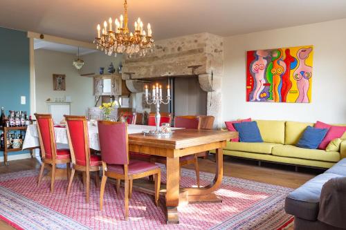 een eetkamer met een houten tafel en rode stoelen bij Le Theureau B&B in Millay