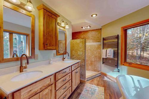 a bathroom with two sinks and a shower at Camp Farrell House in Manitowish Waters