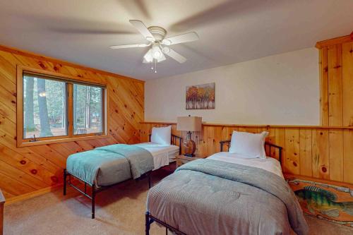 a bedroom with two beds and a ceiling fan at Camp Farrell House in Manitowish Waters