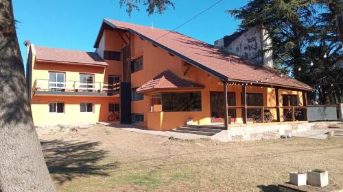 an orange house with a red roof at Hostal Viví La Pampa in Santa Rosa