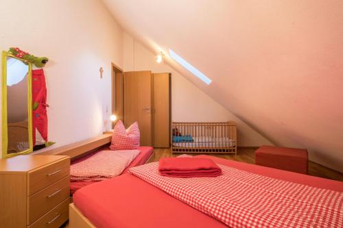 a attic bedroom with two beds and a mirror at Ferienhof Sauter Romanshorn in Neukirch