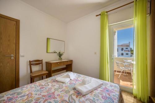 een slaapkamer met een bed en een raam met uitzicht bij Villas Brites nº3 in Burgau