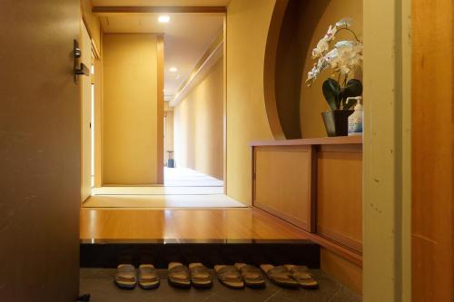 a hallway with a row of pairs of shoes at 熱海の隠れ里 in Atami