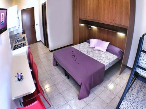 a small room with a purple bed in a kitchen at Residenz Regent Beach Wohnung Living für 4 Personen in Bibione