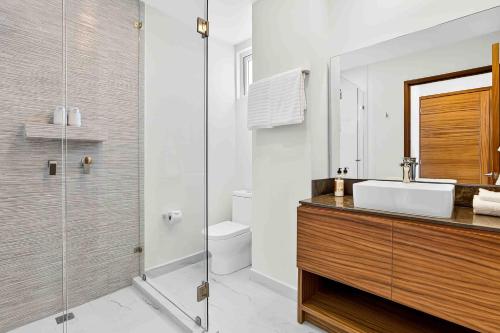 a bathroom with a sink and a glass shower at Blue Wave Hideaway at Quinta Banderas Bay in Bucerías