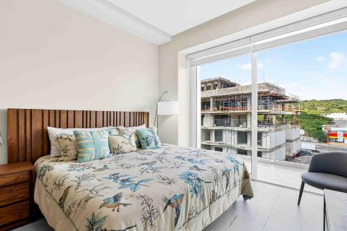 a bedroom with a bed and a large window at Blue Wave Hideaway at Quinta Banderas Bay in Bucerías