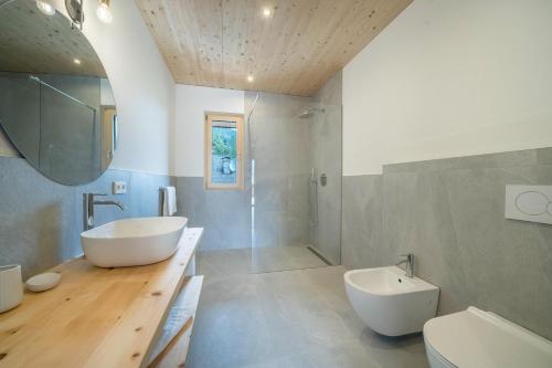 a bathroom with a tub and a sink and a toilet at Naturapartments Alpreid Zirbe in San Pancrazio dʼUltimo