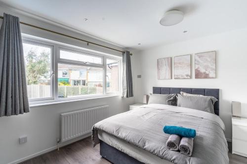 a bedroom with a large bed and a window at Karazo LTD - Luxurious contractor and family friendly 4 bedroom in Croydon with Parking in Croydon
