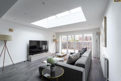 a living room with a couch and a tv at Karazo LTD - Luxurious contractor and family friendly 4 bedroom in Croydon with Parking in Croydon