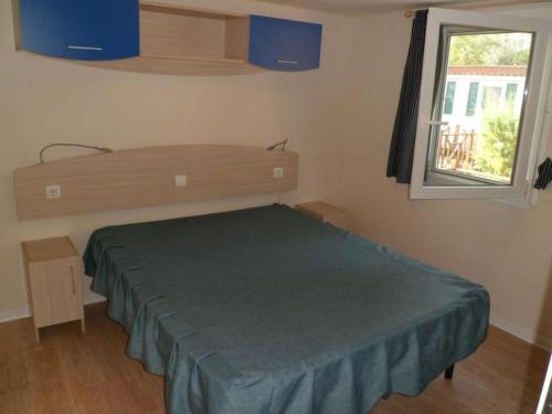 une chambre avec un lit et une fenêtre dans l'établissement Feriendorf Le Tamerici Mobilehome Costa Rei für 6 Personen, à Marina di Cecina
