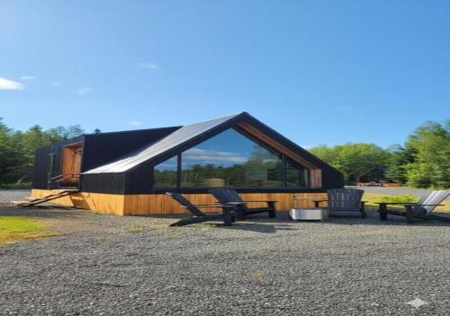 a cabin with two chairs and a large window at Coastal A-Frame, Near Schoodic Point, Acadia in Gouldsboro